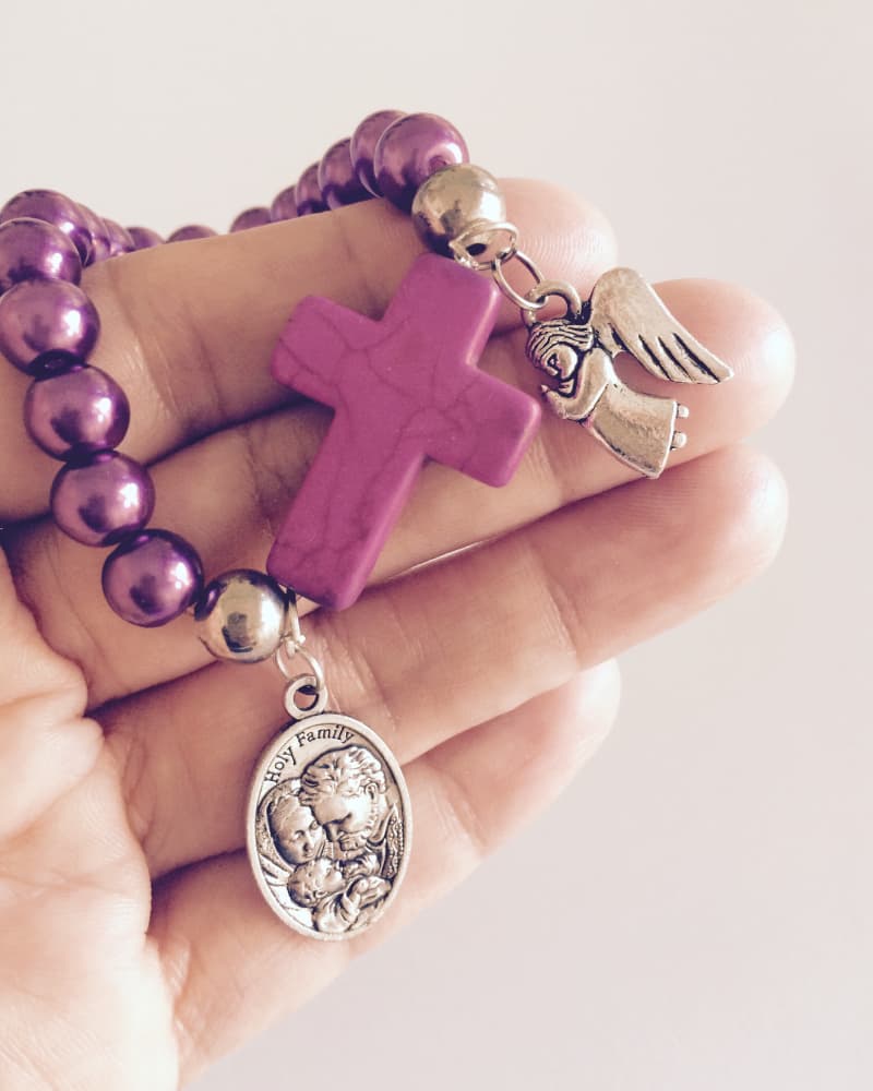 Rosario y medalla de la Sagrada Familia sostenidos con devoción